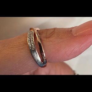 Gold colour ring with crisscross bands on top one gold & one with clear stones